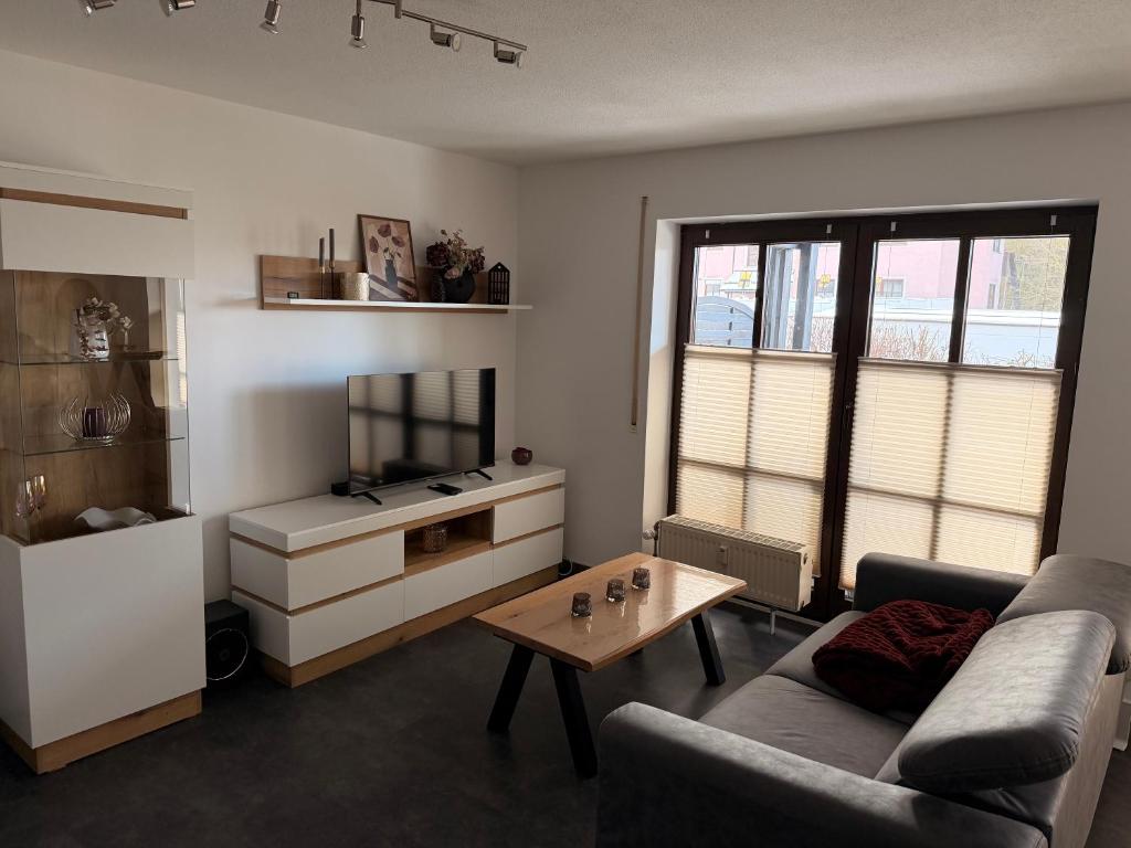 a living room with a couch and a coffee table at Komfortable moderne Ferienwohnung 43 qm in Köditz