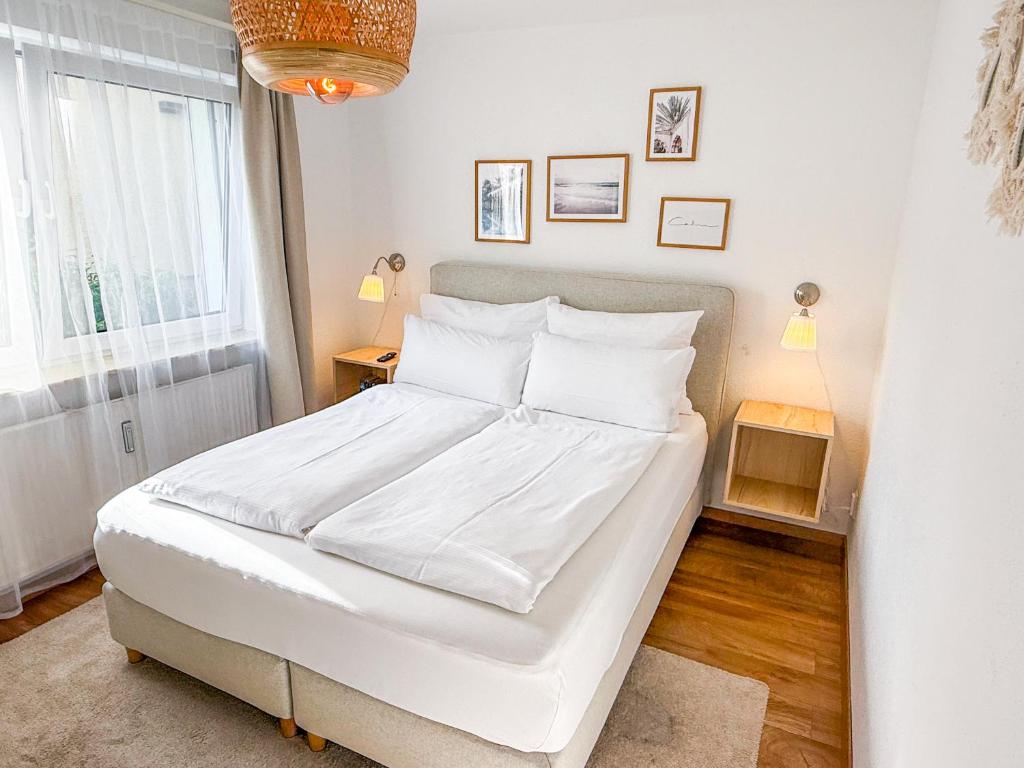 a bedroom with a large bed with white sheets at City Apartments Gerlingen in Gerlingen