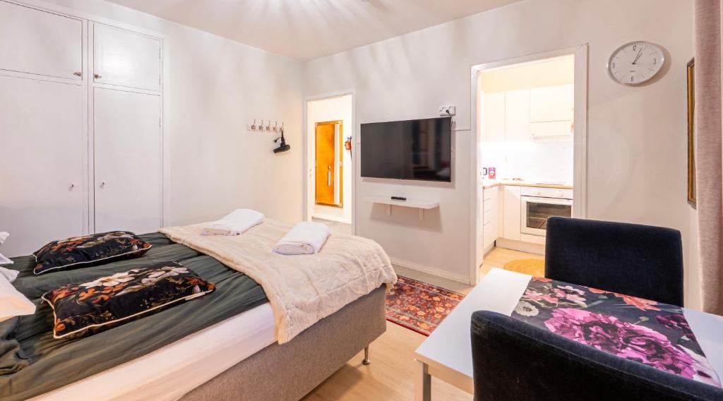 una camera da letto con un letto, un tavolo e una TV di Studio in the city center FREE PRIVATE PARKING with heating plug a Kemi