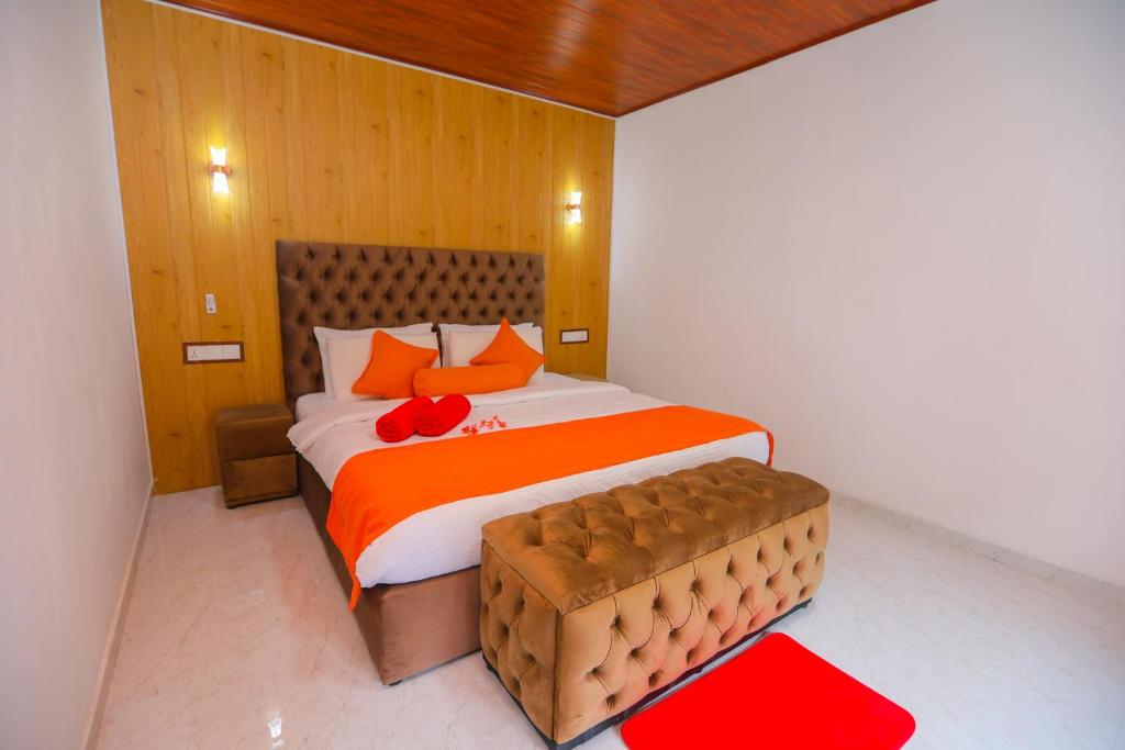 a bedroom with a large bed with orange pillows at Forest Edge Villa in Ella