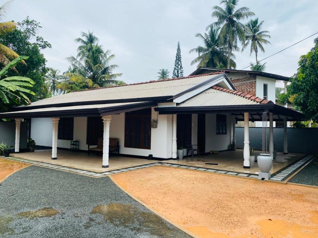 a small white house with a courtyard at Open Sky Villa in Hikkaduwa