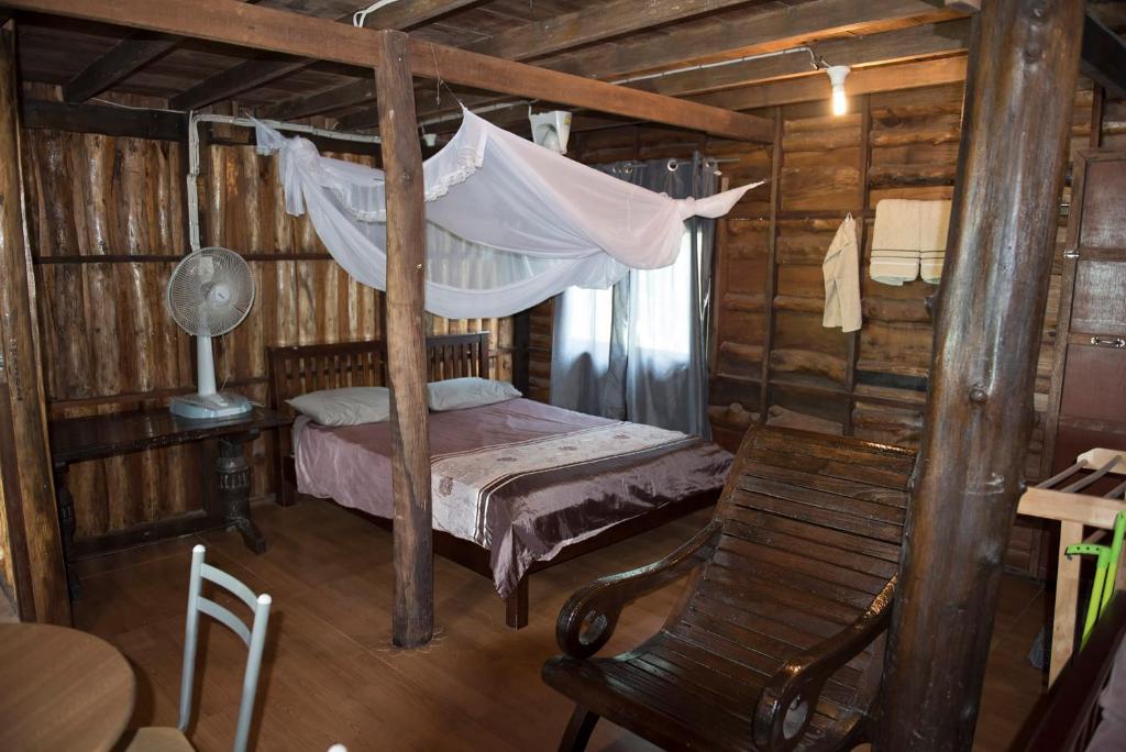 Sunflower Boathouse في جزيرة في في: غرفة نوم بسرير مع أرجوحة وكرسي