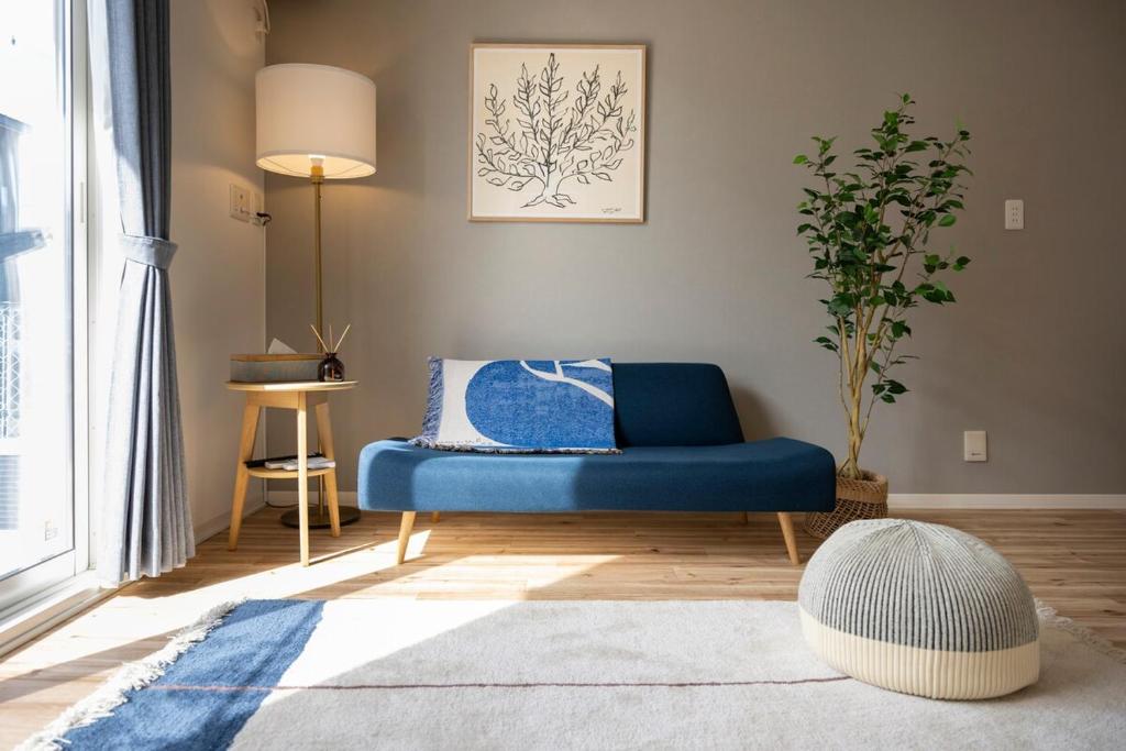 a living room with a blue couch and a rug at Matsumoto 101 in Matsumoto