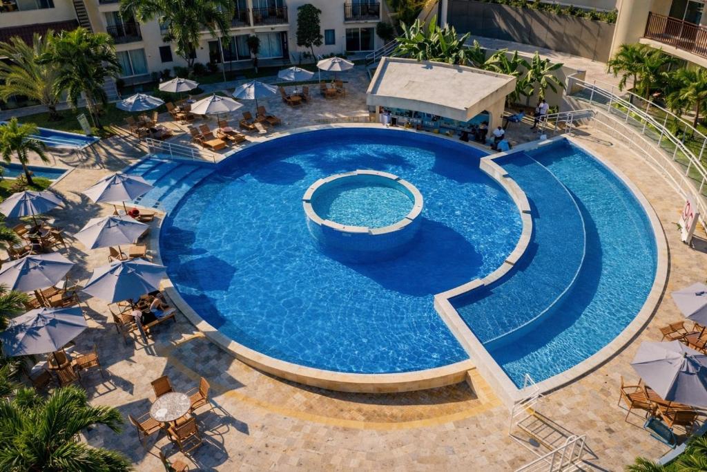 an overhead view of a large swimming pool with umbrellas at Solar Agua Flats Elegance Flat in Pipa