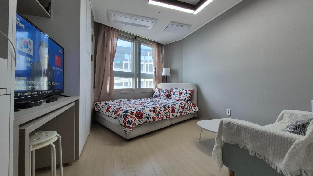 a small room with a bed and a tv at A house with a beautiful sunset in Ansan