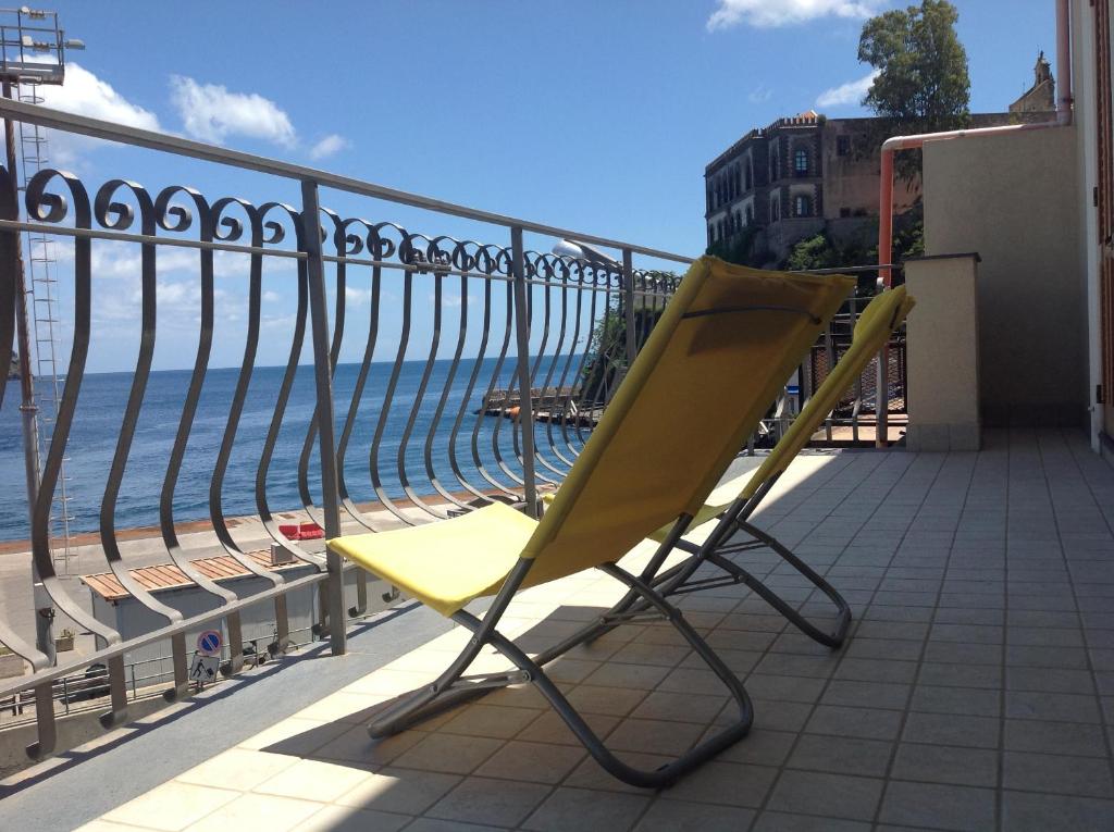 una silla amarilla sentada en un balcón con vistas al océano en Bella Vista en Lipari