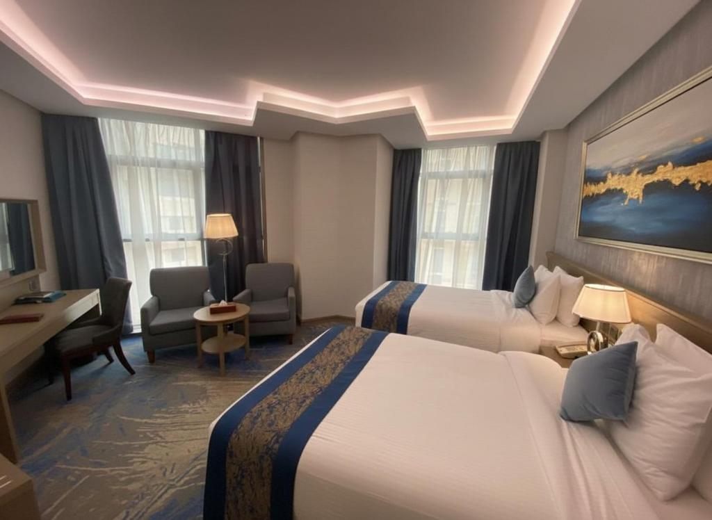 een hotelkamer met twee bedden en een bureau bij Valy Hotel in Al Madinah
