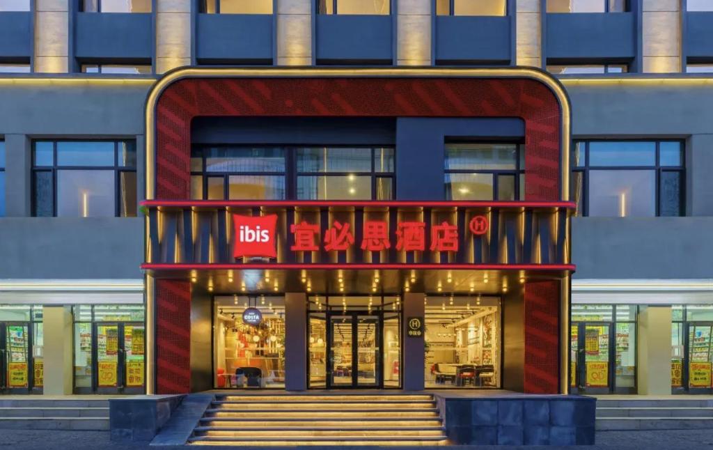 a building with a sign that reads bus at Ibis Dalian Development Zone Wanda Plaza in Jinzhou