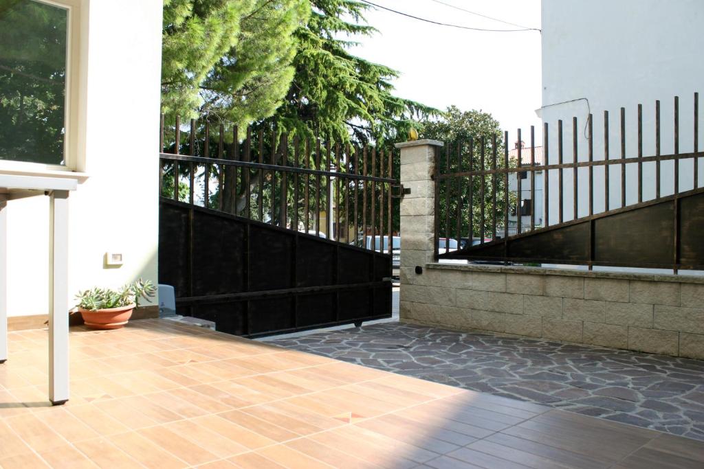 eine Veranda mit einem schwarzen Zaun und einem Gehweg in der Unterkunft Park Apartments in Izola