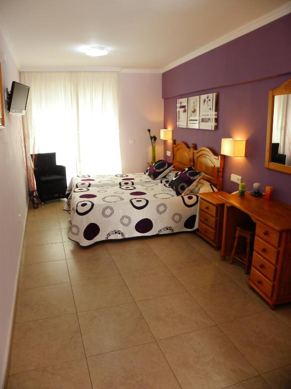 a bedroom with a bed and a desk at Hotel Noguera El Albir in Albir