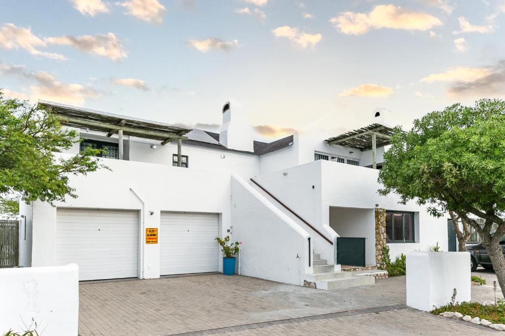 a white house with two garage doors at Abalone Hotel & Villas 2 Bedroom Apartment in Paternoster