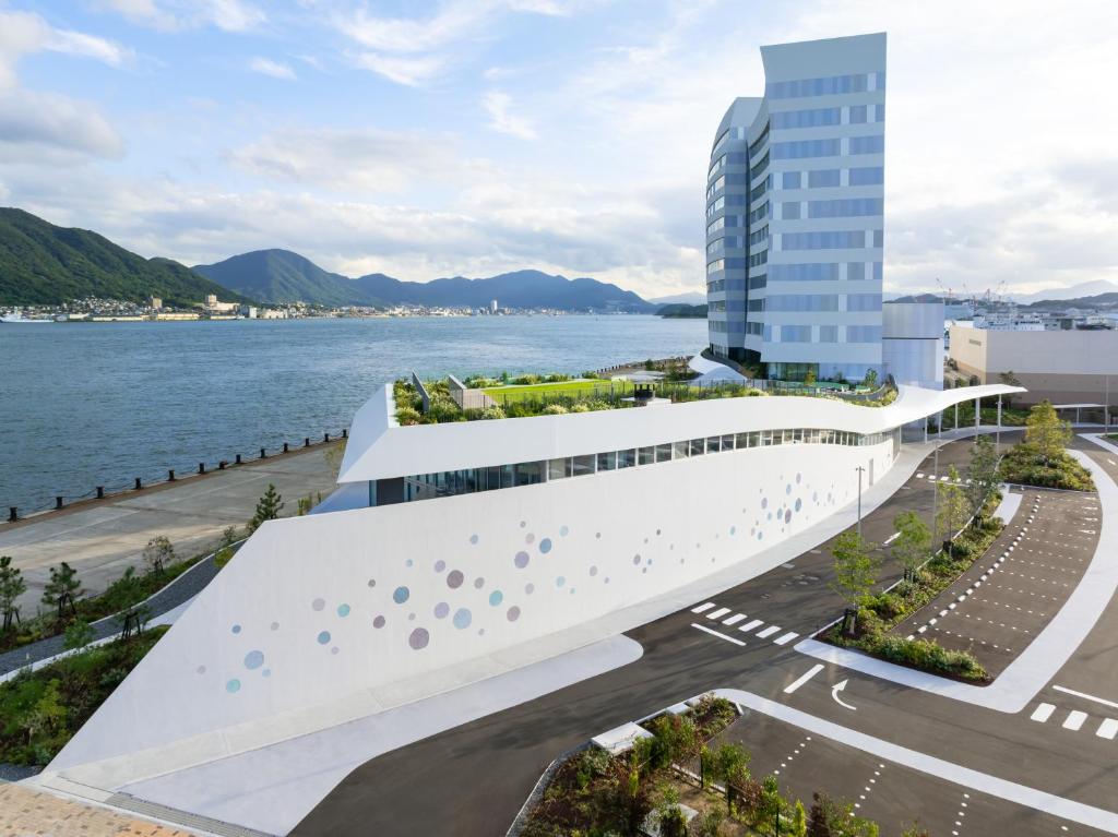 a rendering of a building next to the water at RISONARE Shimonoseki in Shimonoseki