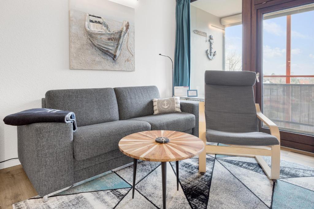a living room with a couch and two chairs at Altes Holzboot in Steinhude