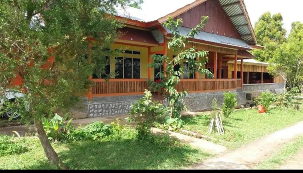 a house with a tree in front of it at Ruteng YosPrima Garden in Lao