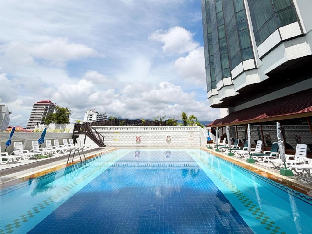 The large outdoor pool is shown from water level with loungers around its deck.