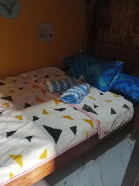 a bed with a comforter with triangles on it at iya lee guest hauz in Capissayan