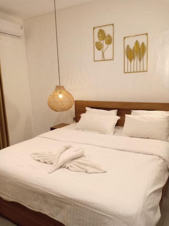 a bedroom with a bed with white sheets and a lamp at Coconut Villa in Kerobokan