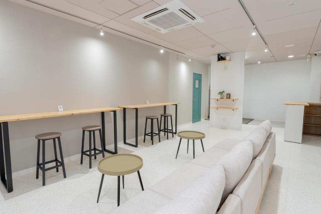 a living room with a couch and bar stools at atic Guesthouse in Takamatsu