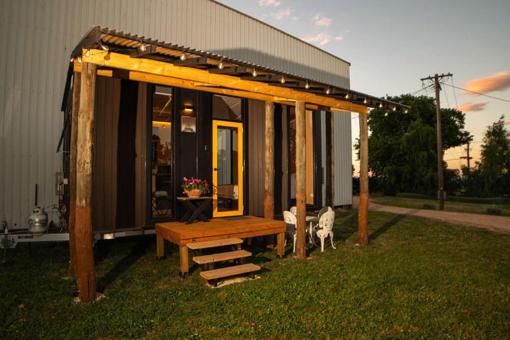 a pavilion with a bench in the grass next to a building at The Orchard View by Tiny Away in Nashdale