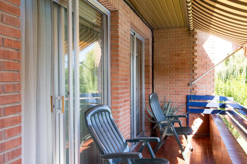 two chairs sitting on a porch next to a window at Pensión La Rioja in Logroño