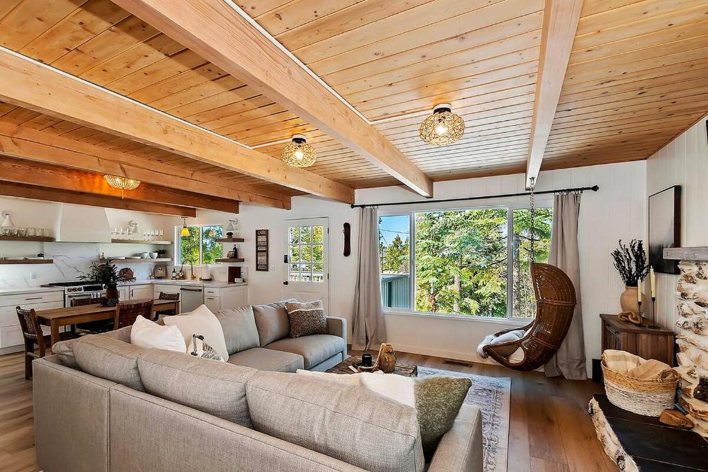 a living room with a couch and a kitchen at Yama Cabin - 5 min walk to the village, EV plug, hot tub, kid & pet friendly in Lake Arrowhead