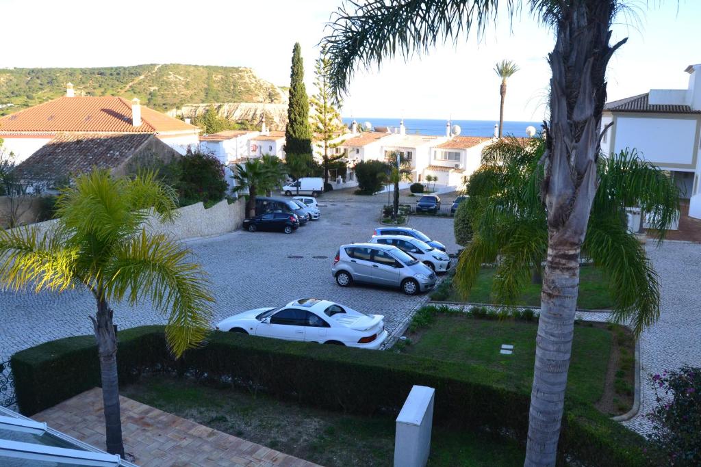 a group of cars parked in a parking lot with palm trees at Palm Bay Apartment in Luz