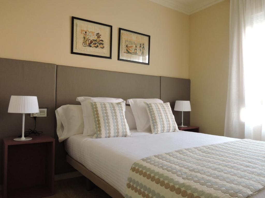 カルドナにあるApartament El Miracleのベッドルーム1室(大型ベッド1台、枕、ランプ2つ付)