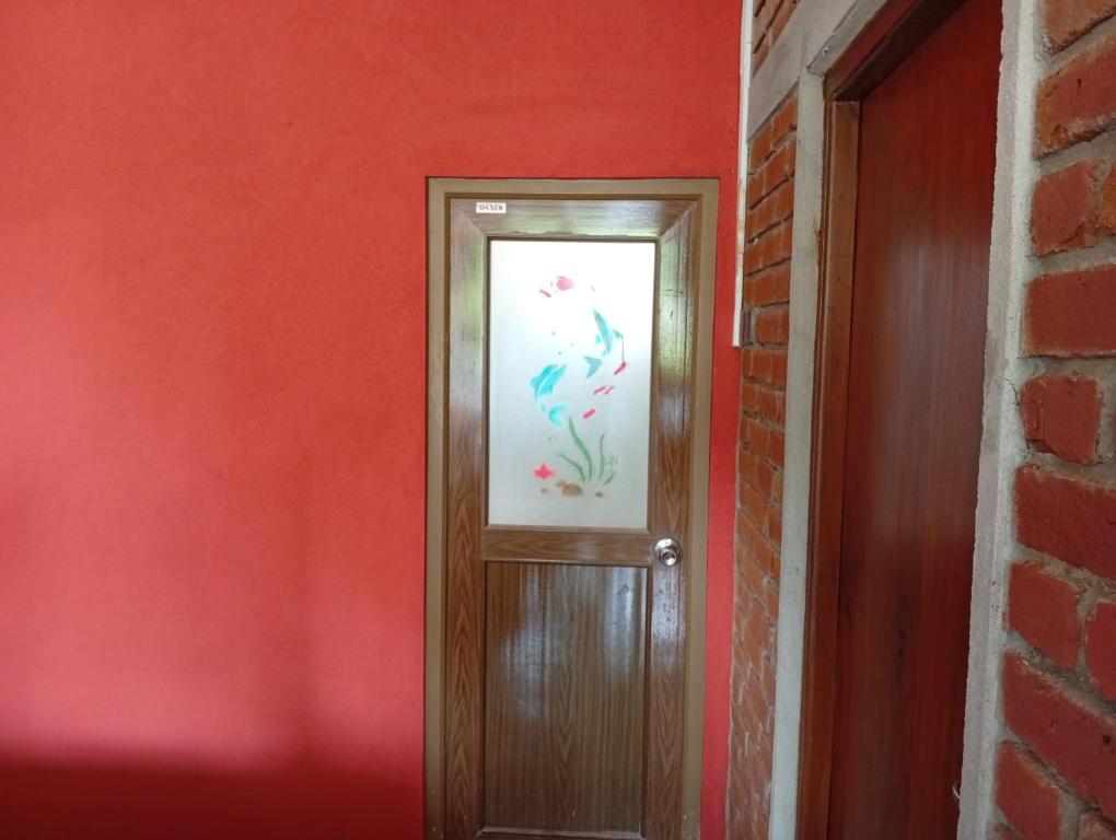 a door with a picture of a fish on the wall at Manilal in Battaramulla