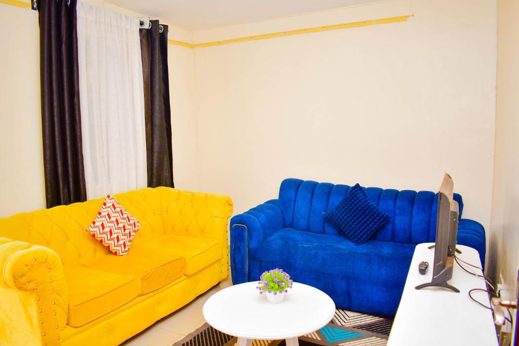 a living room with a yellow couch and a table at Cozy Homes in Thika