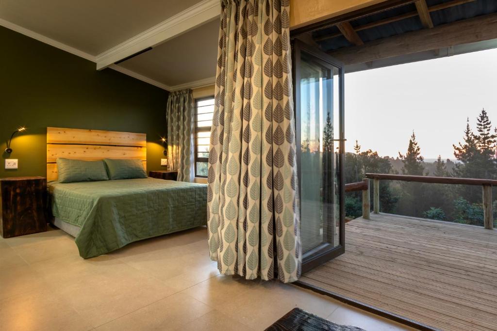 a bedroom with a bed and a large window at Fourfields Hogsback in Hogsback