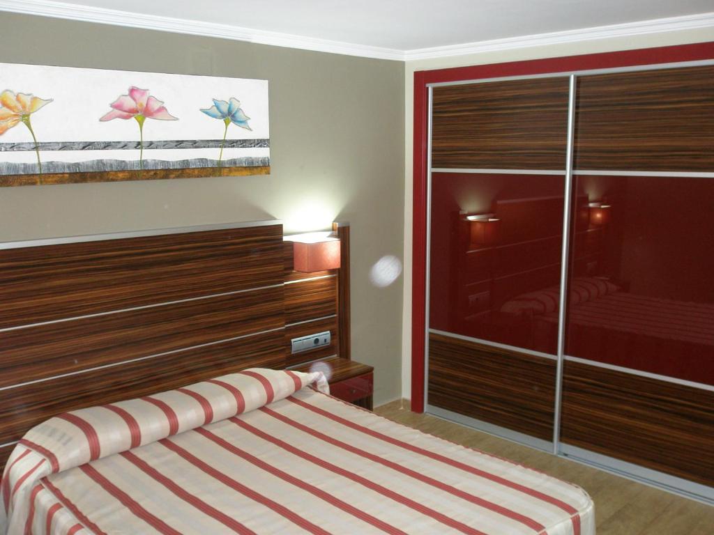 a bedroom with a bed and a large closet at Hotel Noguera El Albir in Albir