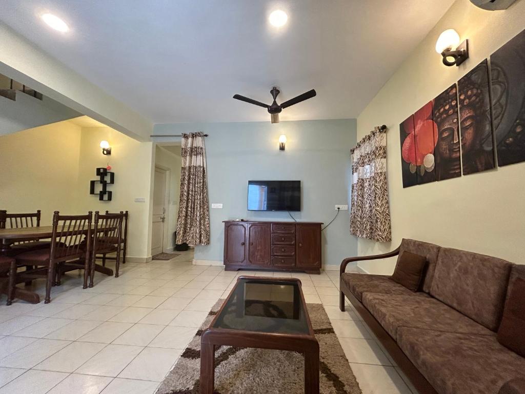 a living room with a couch and a tv at The golden villa in Calangute