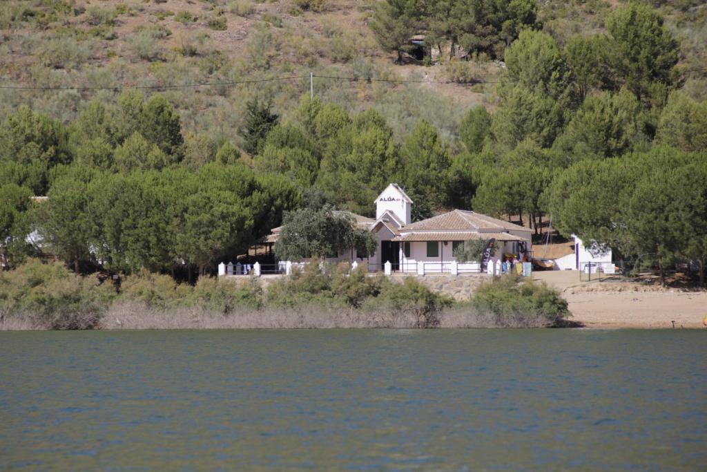 una casa en la orilla de un cuerpo de agua en CENTRO DE OCIO ALÚA Casa Rural Iznájar Lago de Andalucía, en Iznájar