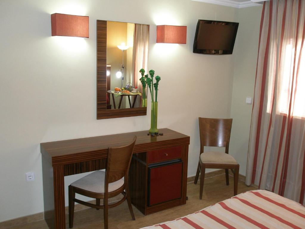 a room with a desk with two chairs and a mirror at Hotel Noguera El Albir in Albir