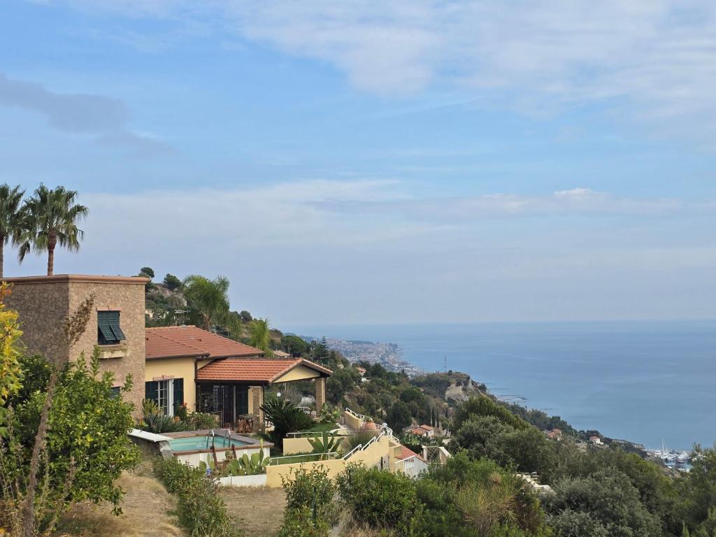 a house on a hill with the ocean in the background at Mie sorelle (tra cielo e mare) in Ventimiglia
