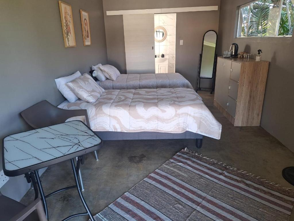 a bedroom with a large bed and a table at 42AtSouth in Vryheid