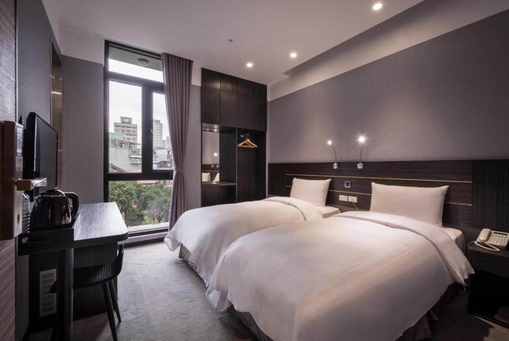 Una habitación de hotel con dos camas y una ventana. en Yi Su Hotel-Taipei Ningxia, en Taipéi