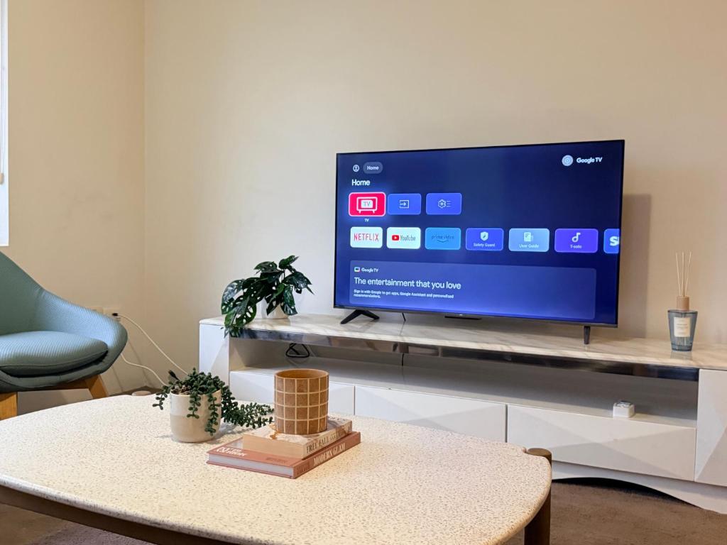 a living room with a flat screen tv on a table at Epping Station Apartments in Epping