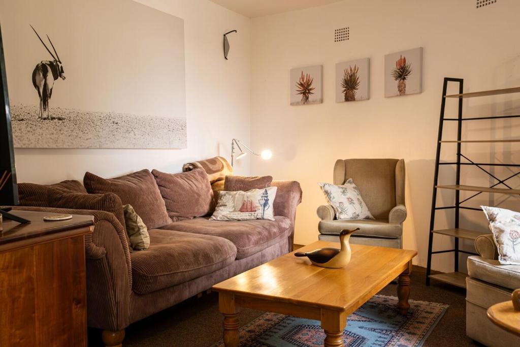 a living room with a couch and a table at Sunrise Cottage in Wilderness