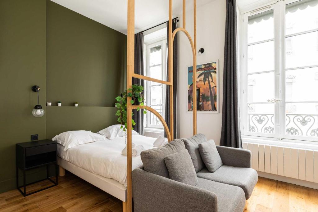 a bedroom with a bed and a couch in it at Cosy studio - 2P - Bellecour in Lyon