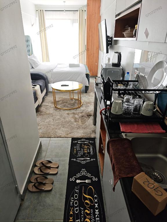 a room with a kitchen and a living room at Tsavo Stanley in Kiambu