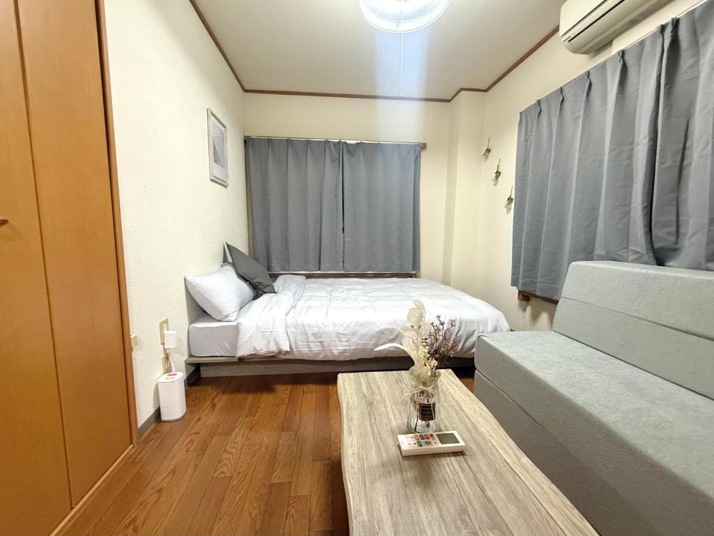 a small bedroom with a bed and a couch at Nogata RelaxingHome E2 in Tokyo