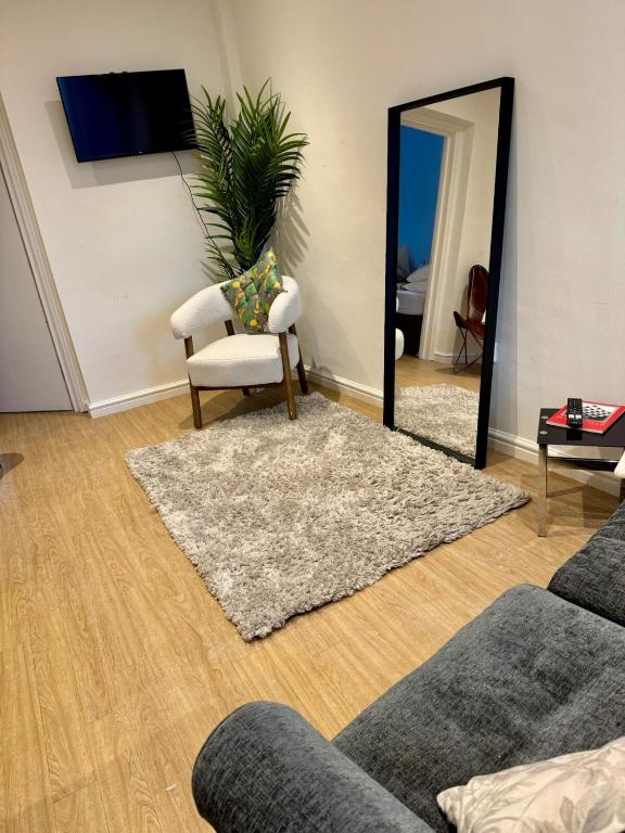 a living room with a chair and a mirror at Charming 6 Bed Flat in Bedminster - Sleeps 8 in Bristol
