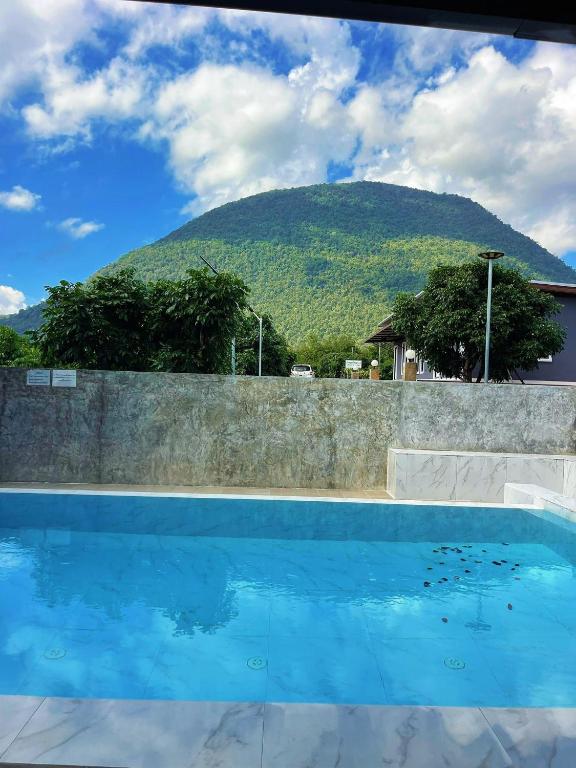 a swimming pool with a mountain in the background at Yankoi Mountains view in Chiang Dao