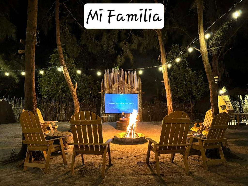 a fire pit with chairs and a screen at night at Mi Familia CAMP in San Felipe