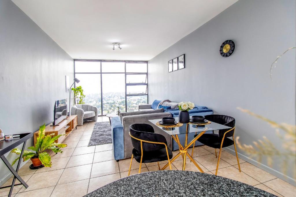 un soggiorno con un divano e un tavolo di Skyline Hideout XL King Bed FREE Parking Views a Edenvale