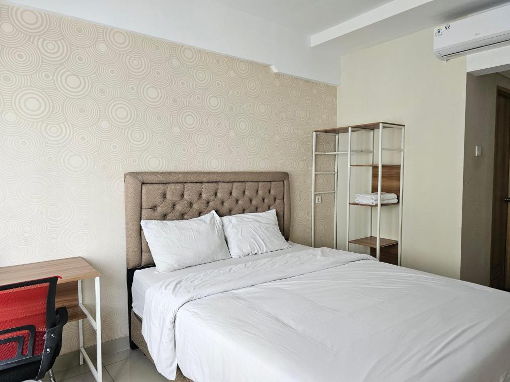 a bedroom with a large white bed and a desk at Padina Soho And Residence in Kebonbesar