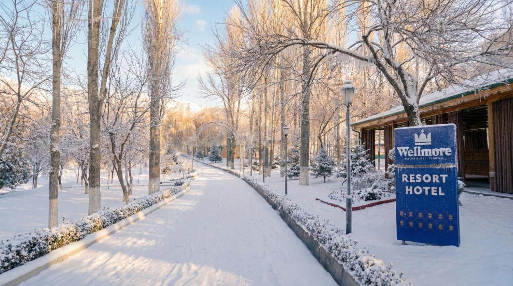 a park covered in snow next to a hotel at Wellmore Resort in Yusufkhona