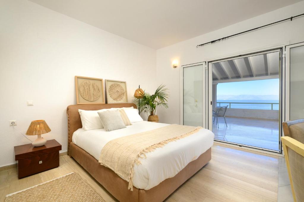 a bedroom with a bed and a sliding glass door at Aether Messonghi - Seaview Collection Corfu in Mesongi