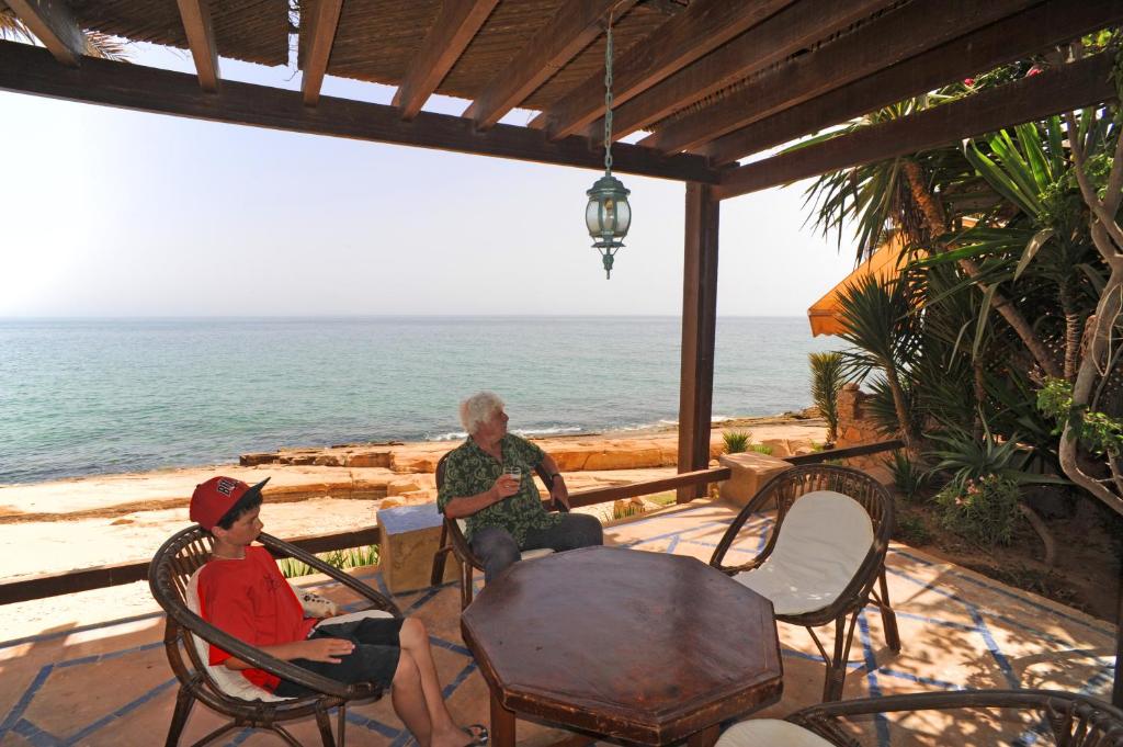 twee personen op een patio met uitzicht op de oceaan bij Villa Oceane in Taghazout